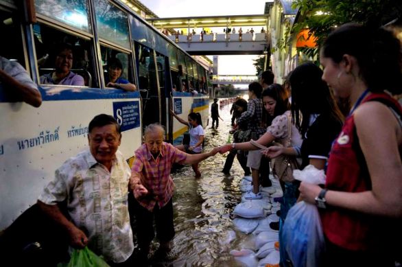 In the area of Payonyothin and Latprao roads, commuting in water clogs major street is time consuming. Althought the underground and the elevated trains sysms are still working, once you get at the stations, the hardship starts. An elderly woman getting a hand at the bus station.